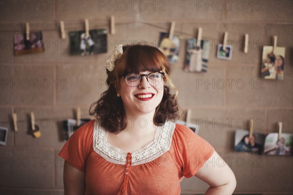 Caucasian photographer standing near hanging photographs