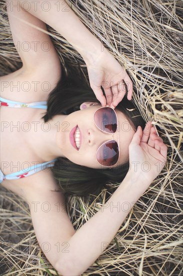 Caucasian woman laying in hay