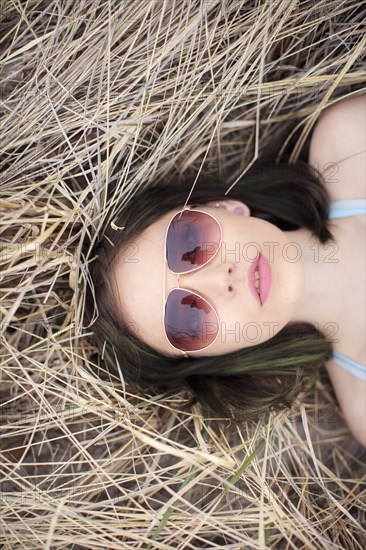 Caucasian woman laying in hay