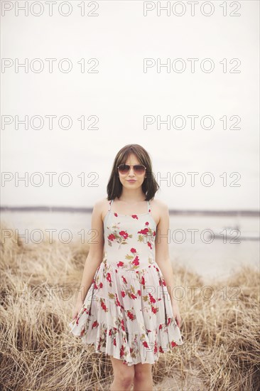 Caucasian woman standing in beach grass