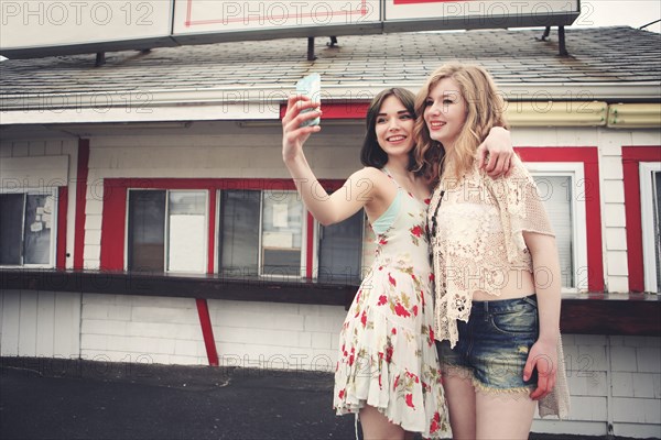 Caucasian friends taking selfie with cell phone