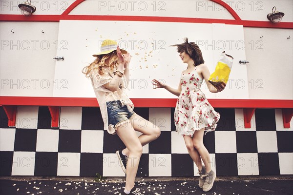 Caucasian friends having popcorn fight outdoors