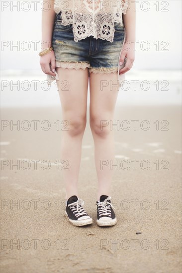 Caucasian teenage girl standing on beach