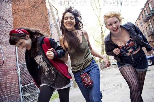 Laughing friends playing on city sidewalk