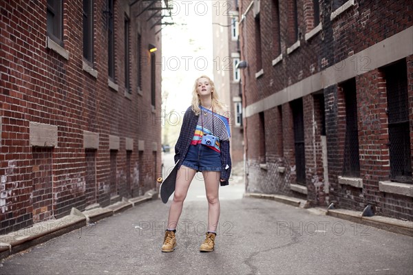 Caucasian woman standing in city alleyway