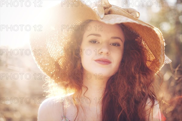 Hispanic woman wearing sun hat outdoors