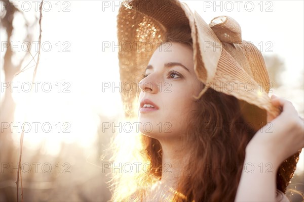 Hispanic woman wearing sun hat outdoors