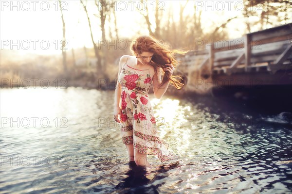 Hispanic woman standing in rural lake