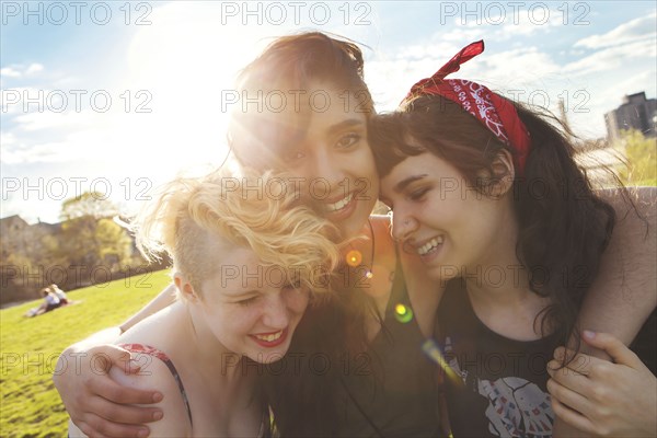 Friends hugging in sunny urban park