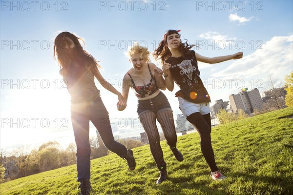 Friends holding hands in urban park