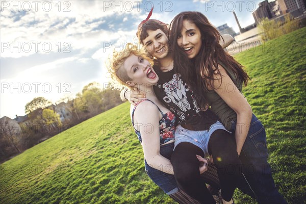 Women carrying friend in urban park