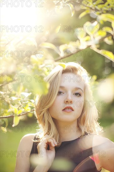 Caucasian woman standing under tree branches