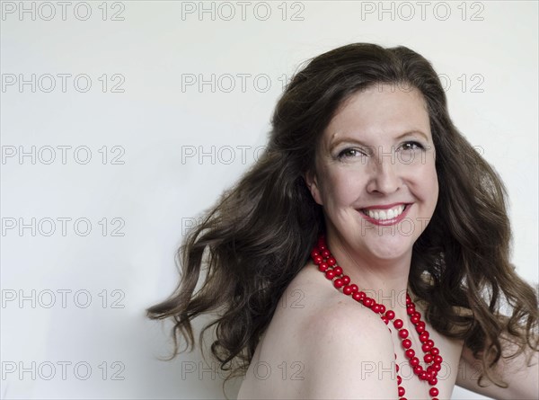 Close up of smiling woman wearing bead necklace