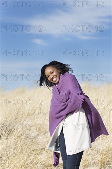 Woman wrapped in shawl on beach