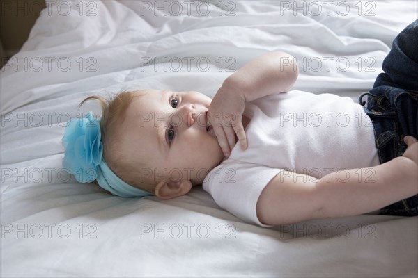 Close up of baby girl laying on bed