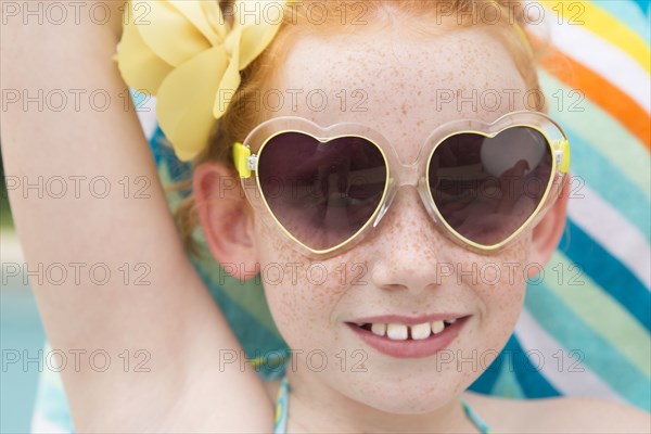 Close up of Caucasian girl wearing heart-shaped sunglasses