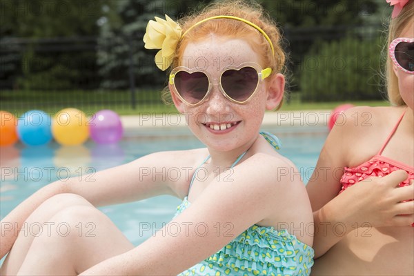 Caucasian girls smiling near swimming pool