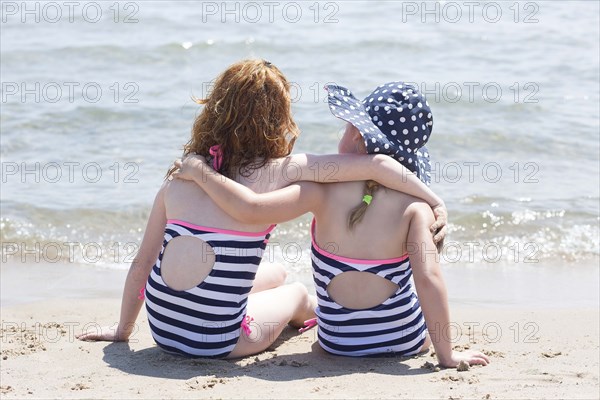 Caucasian girls hugging on beach