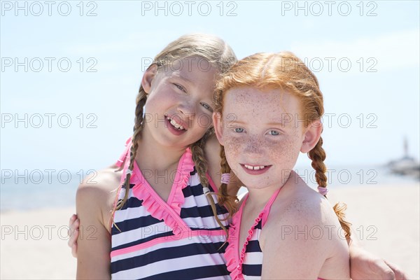 Caucasian girls hugging on beach