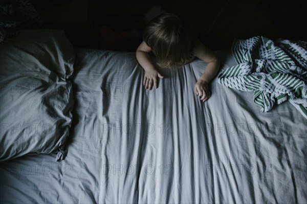 Mixed race girl climbing on bed