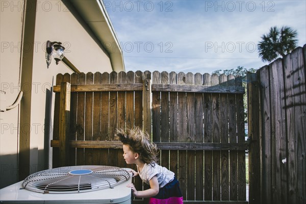 Hair of mixed race girl blowing from outdoor fan