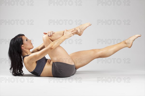 Caucasian woman stretching leg on floor