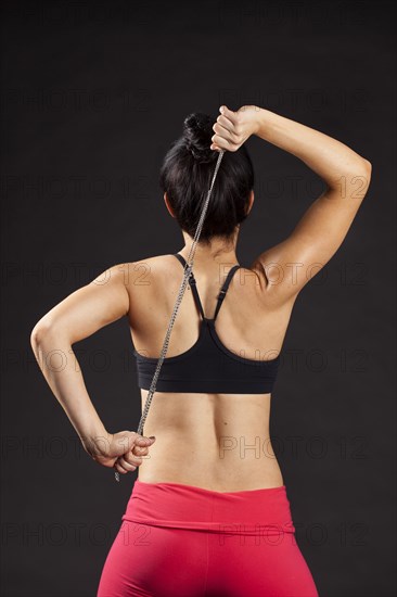 Caucasian woman exercising with rope behind back