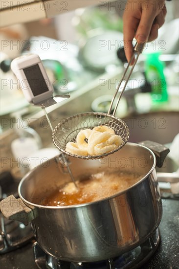 Close up of woman frying onions in kitchen