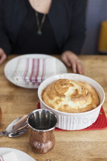 Girl sitting near baked souffle on table