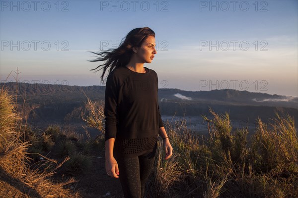 Woman admiring rural landscape from mountain path