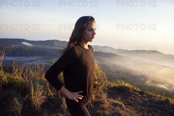 Woman admiring rural landscape from mountain path