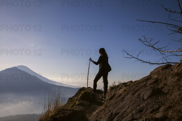 Woman admiring rural landscape from mountain path