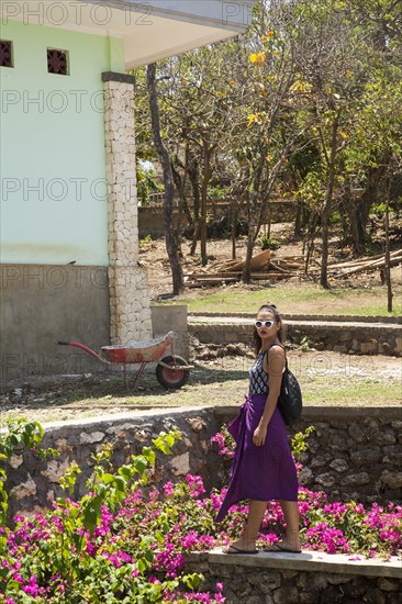 Woman walking by rock wall in garden