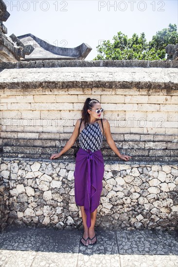 Woman leaning on rock wall at monument