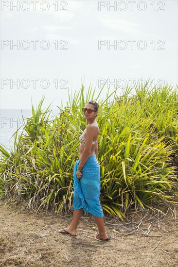 Woman walking near beach grass