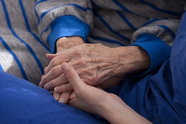 Close up of granddaughter holding hands of grandmother