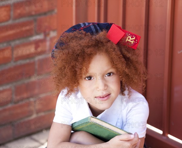 Girl in school uniform holding book