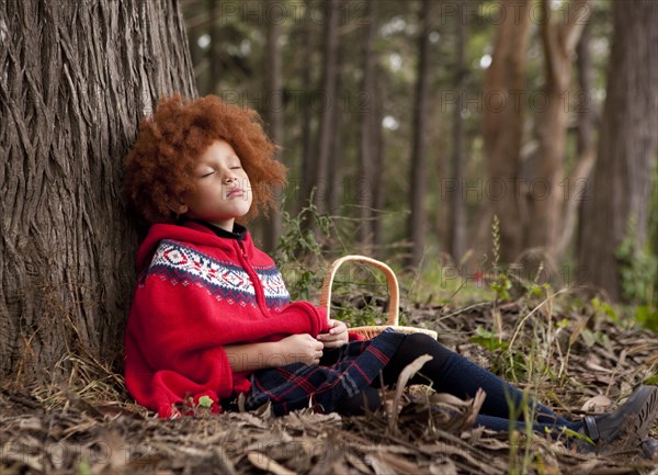 Girl napping under tree in park