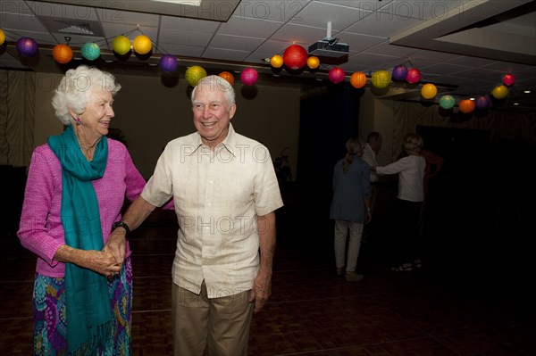 Older Caucasian couple dancing at party in retirement home