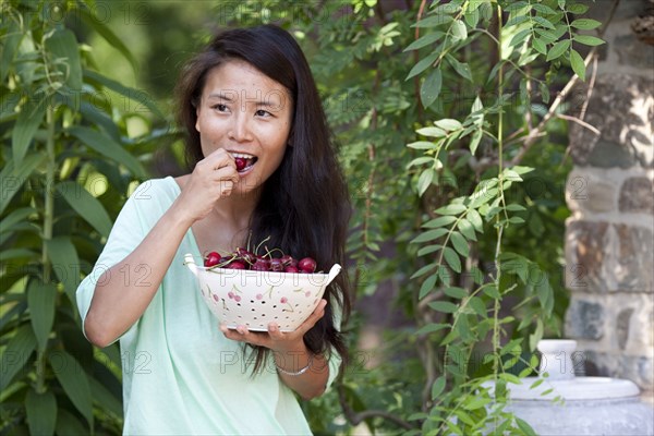 Woman eating grapes in garden