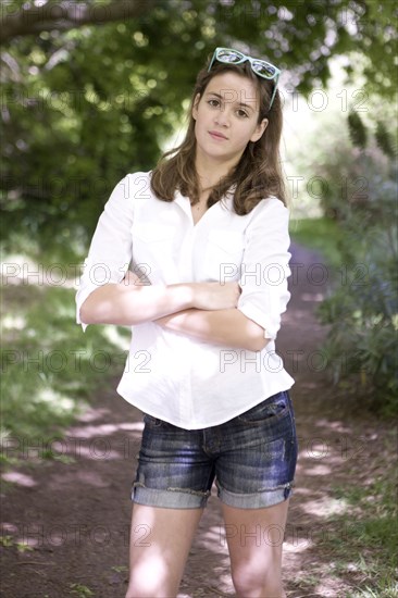 Caucasian teenage girl standing on dirt path