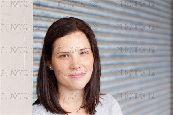 Close up of smiling woman standing by garage door