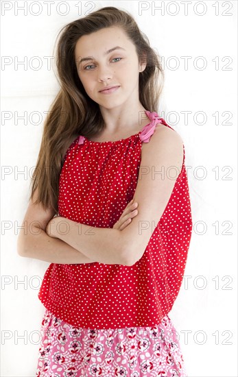 Serious teenage girl standing with arms crossed
