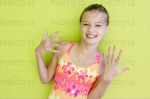 Smiling Caucasian teenage girl displaying fingernails