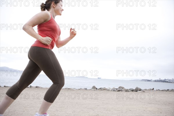 Caucasian woman running on beach