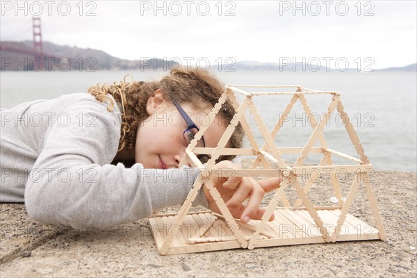 Caucasian girl examining project on wall over ocean