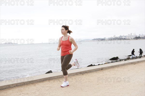 Caucasian woman running on waterfront