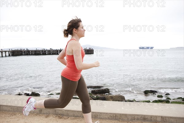 Caucasian woman running on waterfront