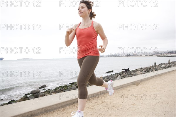 Caucasian woman running on waterfront