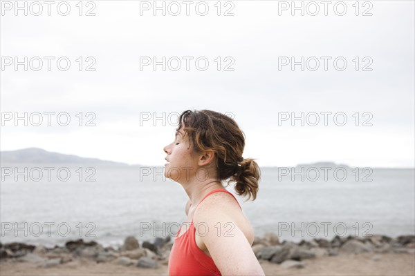 Caucasian woman resting on rocky beach